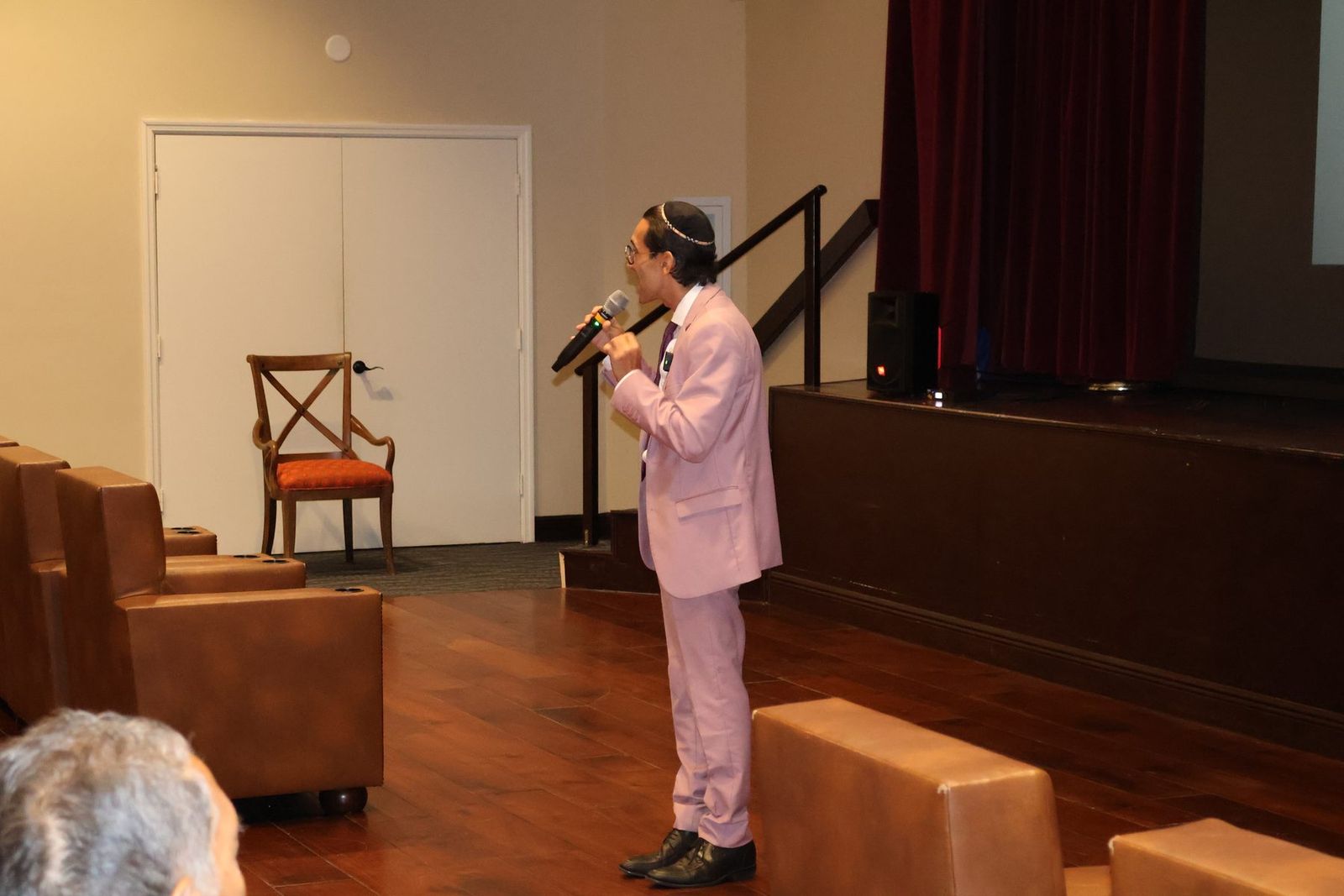 Dr. Erik Ilyayev presenting on stage at Caregivers’ Day